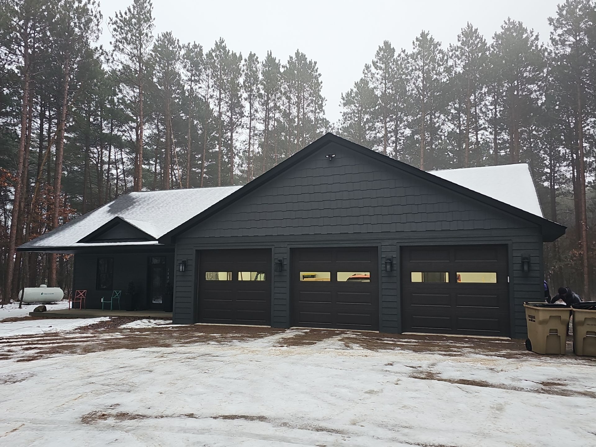 Modern dark siding with three car garage